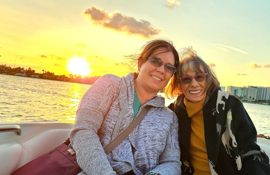 A mother and daughter posing for a photo during a Sandhill Charters sunset cruise