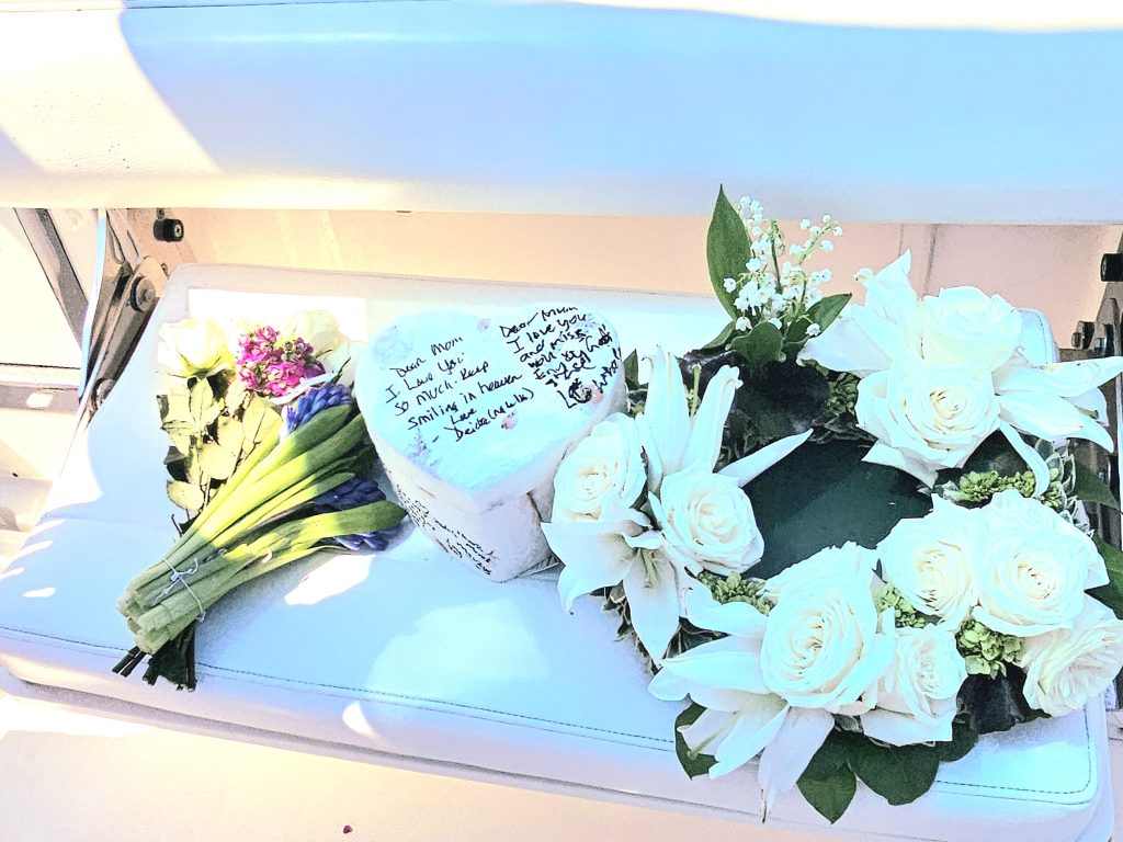 Decorative Flowers and a biodegradable urn for an Ocean Ash Scattering on display