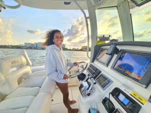 A girl having a great time at the helm and driving the Bonnie Lee of Sandhill Charters