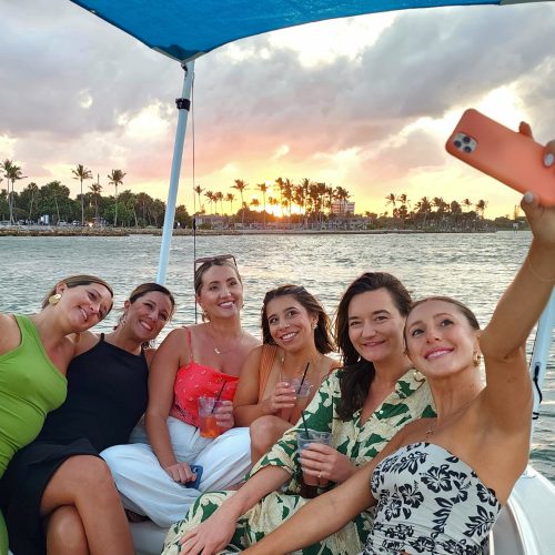 Six friends posing for a selfie on the bow of the Bonnie Lee of Sandhill Charters taken at sunset